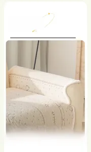 Detail of white plush sofa armrest cover with elegant embroidery and round edges