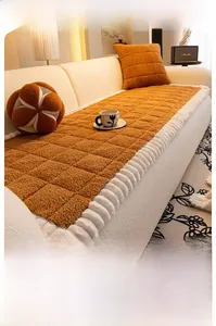 Detail of caramel thick fleece sofa cover with quilted pattern and white ruffle edge