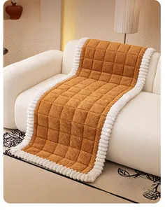 Detail of ginger plush sofa cushion with white ruffled edges and square quilted texture