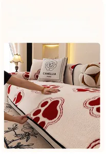 Detail of soft cream plush sofa cover with red patterns and camellia logo pillow