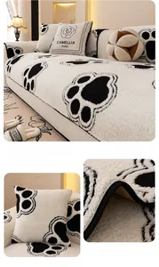 Detail view of thick plush sofa cushion with black paw prints and floral camellia pillow