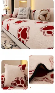 Close-up of thick plush sofa cover with cute black paw prints and floral embroidery