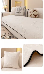 Detail showing the dog paw quilted pattern and plush texture of the cream sofa cover