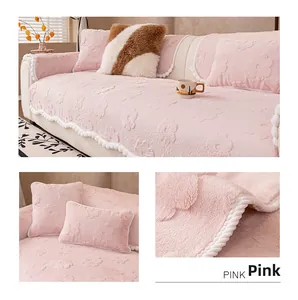 Detail of pink plush sofa cover with flower embossing and decorative pom-pom fringe