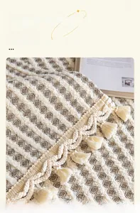 Close-up of thick woven sofa cover featuring wavy geometric patterns and tassel edges