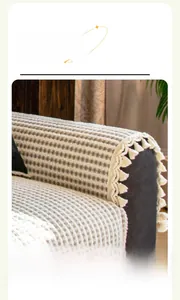 Close-up of luxury thick knit sofa cover with beige stripes and handmade fringe trim