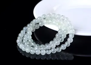 Primer plano de pulsera de cuarzo rutilado verde natural de tres vueltas sobre fondo negro