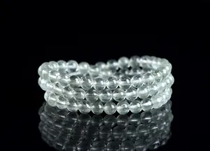 Primer plano de pulsera de cuarzo rutilado verde natural con tres vueltas en fondo negro
