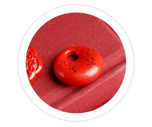 Detailed view of a red cinnabar Ping An lock pendant with carved Chinese characters