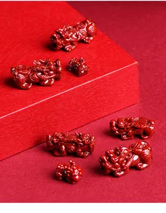 Detailed view of red cinnabar Pixiu carvings on a matching tiered display stand