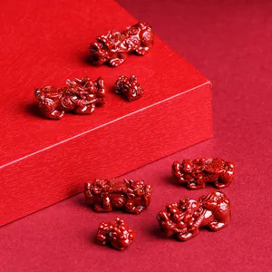 Natural cinnabar Pixiu crystal ornaments in vibrant red set against a textured base