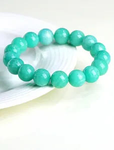 Macro detail of natural blue-green amazonite beads with smooth texture on a ceramic tray