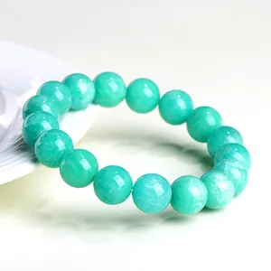 Polished natural amazonite round bead bracelet in teal green on minimalist white background
