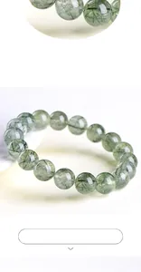 Detail view of natural green rutilated quartz beads with clear needle inclusions