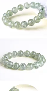 Macro shot of natural green rutilated quartz beads with clear texture and needles