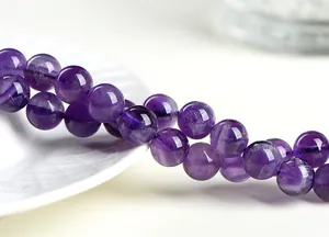 Dettaglio macro di perle tonde in ametista naturale con trame di pietra uniche interne