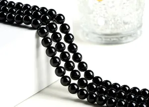 Macro shot of polished black tourmaline round beads with mirror-like finish and high luster