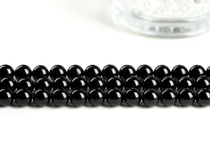 Macro shot of high-grade black tourmaline beads with smooth polished mirror finish