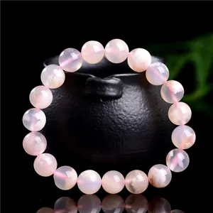 Bracelet en agate fleur de cerisier naturelle avec perles roses sur support noir
