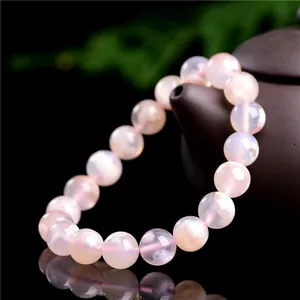 Bracelet en agate fleur de cerisier avec perles roses sur théière sombre