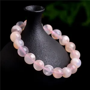 Bracelet en perles d'agate fleur de cerisier naturelle sur un flacon décoratif noir