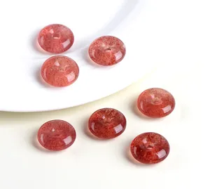 Close-up of seven strawberry quartz donut beads on a white ceramic plate