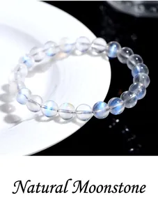 Macro shot of natural blue moonstone beads on a ceramic plate with elegant blue glow