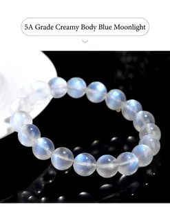 Detailed view of 5A Grade Creamy Blue Moonstone bracelet with visible blue fire on a black base