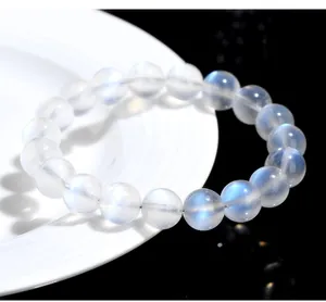 Macro detail of blue moonstone beaded bracelet with luminous highlights on white ceramic
