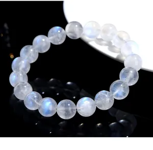 Close-up of natural blue moonstone beaded bracelet with bright blue sheen on dark surface