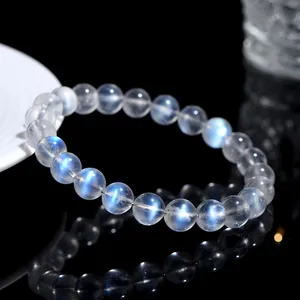 Natural moonstone bracelet with blue fire effect on a reflective black background