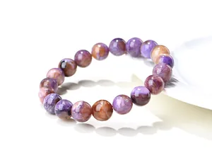 Gros plan d'un bracelet en perles de charoïte naturelle avec texture polie lisse