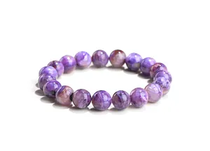 Détail d'un bracelet en perles de charoïte naturelle montrant des textures minérales