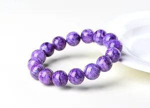 Détail des perles de charoite montrant la texture fibreuse violette et l'éclat soyeux