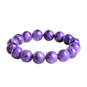 Bracelet en charoïte naturelle aux perles violettes avec motifs fibreux sur blanc