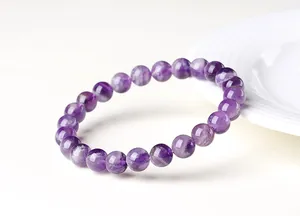 Gros plan d'un bracelet en améthyste naturelle avec des perles violettes dégradées