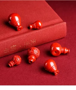 Detalle de cuentas de calabaza en cinabrio rojo con tallas sobre fondo de tela roja