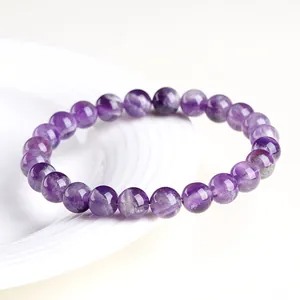 Bracelet en améthyste naturelle avec perles de cristal violettes sur assiette blanche