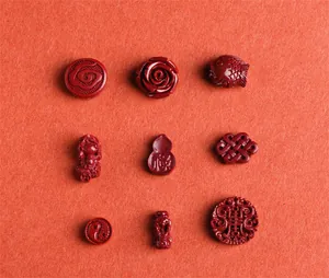 Macro view of cinnabar red beads with traditional Chinese carved floral and koi patterns