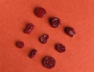 Detailed view of red cinnabar carved beads featuring fish, gourd, and rose patterns