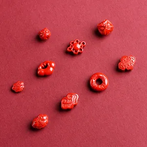 Carved cinnabar charms featuring traditional Ruyi, fortune plaques, and red cinnabar beads