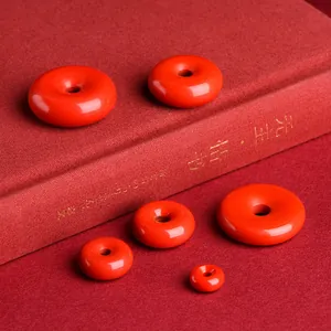 Natural cinnabar Ping'an kou pendants in six sizes displayed on red vintage books