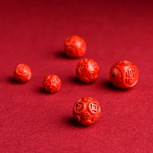 Red cinnabar bead featuring traditional copper coin engraving for jewelry making