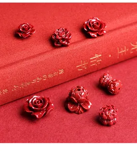 Macro detail of red cinnabar flower beads including lotus and rose carvings