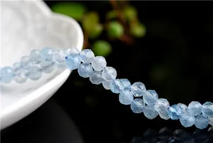 Detailed macro view of faceted natural aquamarine round beads with light blue clarity