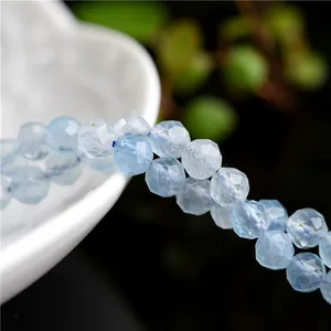 Faceted natural aquamarine beads with light blue gemstones on a dark background
