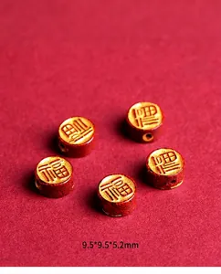 Detailed view of red cinnabar crystal spacers with gold Fu character for DIY jewelry