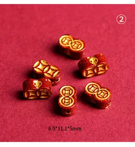 Detailed view of red cinnabar beads with gold coin patterns and Chinese lucky motifs