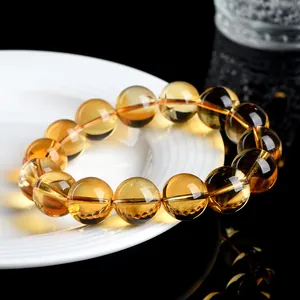 Natural Brazilian citrine beaded bracelet on white ceramic dish with black background