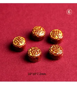 Macro detail of red cinnabar bead with golden Fu character and Chinese knot for DIY jewelry